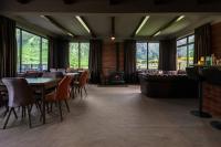 a dining room with tables and chairs and a fireplace at Panorama Ushba in Mestia
