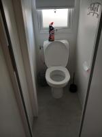 a small bathroom with a white toilet with a window at Mobil-home Les Dunes de Contis in Saint-Julien-en-Born