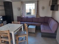 a living room with a purple couch and a table at Mobil-home Les Dunes de Contis in Saint-Julien-en-Born