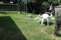 a couple of white chairs sitting in a yard at REZ DE JARDIN AU COEUR DES PYRENEES in Agos-Vidalos