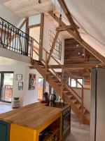 a kitchen with a wooden staircase in a house at Le grenier a foin in Breitenbach-Haut-Rhin