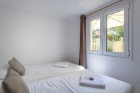 two beds in a room with a window at Villa des Sables in Lège-Cap-Ferret