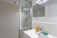 a white bathroom with a sink and a shower at Villa des Sables in Lège-Cap-Ferret