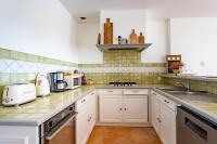 a kitchen with white cabinets and a sink at Villa des Sables in Lège-Cap-Ferret