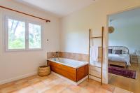 a bathroom with a bath tub and a bed at Villa des Sables in Lège-Cap-Ferret