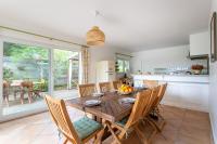 a kitchen and dining room with a wooden table and chairs at Villa des Sables in Lège-Cap-Ferret