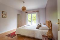 a bedroom with a large bed with a window at Villa des Sables in Lège-Cap-Ferret