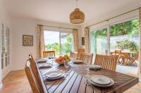 a dining room with a wooden table with a bowl of fruit at Villa des Sables in Lège-Cap-Ferret