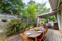 a wooden deck with a wooden table and chairs at Villa des Sables in Lège-Cap-Ferret