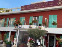 Un edificio rojo con persianas verdes y un hotel. en Hôtel La Villa des Oliviers, en Cagnes-sur-Mer