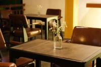 a vase of flowers on a table with chairs at Tuong Boutique Resort Mui ne in Mui Ne