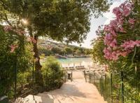 a walkway leading down to a beach with pink flowers at Vue panoramique mer et collines in Grimaud