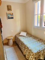 a small bedroom with a bed and a window at Vue panoramique mer et collines in Grimaud