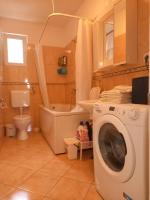 a bathroom with a washing machine and a toilet at Apartman P&amp;M in Makarska