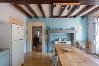 a kitchen with a wooden table and a refrigerator at ROCHE-LOIRE in Le Thoureil