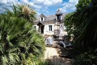 an old house with palm trees in front of it at ROCHE-LOIRE in Le Thoureil