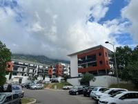 a parking lot with cars parked in front of buildings at T2 avec très grande terrasse in Bastia