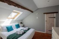 a bedroom with a bed with blue pillows on it at ROCHE-LOIRE in Le Thoureil