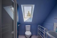 a blue bathroom with a toilet and a window at ROCHE-LOIRE in Le Thoureil
