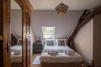 a bedroom with two beds and a mirror at ROCHE-LOIRE in Le Thoureil