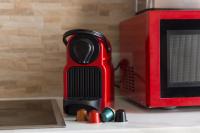 a red appliance sitting on a counter next to a microwave at Le Brooklyn sur Seine, T2 proche Paris in Vitry-sur-Seine
