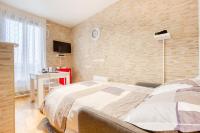 a bedroom with a bed and a brick wall at Le Brooklyn sur Seine, T2 proche Paris in Vitry-sur-Seine