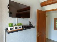a flat screen tv on a wall with a shelf at Cadre d&#39;exception in Orange