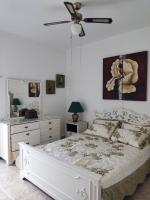 a white bedroom with a bed and a ceiling fan at KATKA Karavas in Kythira