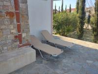 two chairs sitting next to a wall on a patio at KATKA Karavas in Kythira