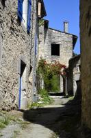 an alley in a stone building with red flowers at Gîte &#39;An Kay Ou&#39; - Le Grand Barry in Pontaix