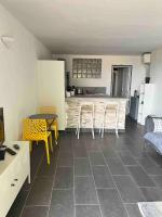 a living room with a kitchen and a table and chairs at Jolie T2 bord de mer corse du sud in Conca