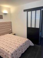 a bedroom with a bed and a black door at Jolie T2 bord de mer corse du sud in Conca