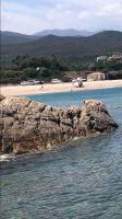 a large rock in the water next to a beach at Jolie T2 bord de mer corse du sud in Conca
