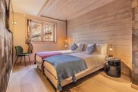 a bedroom with a bed and a wooden wall at Bleu Eskape - Appartement in Megève
