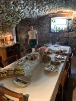 een vrouw in een keuken met een tafel met eten bij Bed & Breakfast Casa Marinella in Lenna