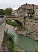 a stone bridge over a river in a city at Sur le Pont in Vaison-la-Romaine