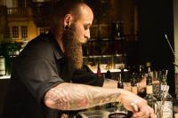 a man with a tattoo on his arm sitting at a bar at Hotel Rhönkitz in Bad Kissingen