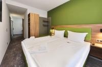 a bedroom with a large white bed with a green wall at Hotel Rhönkitz in Bad Kissingen