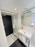 a white bathroom with a shower and a sink at Residence OLit Cathédrale in Strasbourg