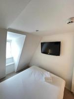 a bedroom with a bed and a tv on the wall at Residence OLit Cathédrale in Strasbourg