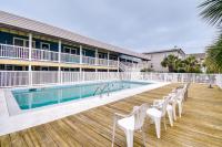 einen Pool mit weißen Stühlen auf einer Holzterrasse in der Unterkunft Steps to Ocean North Myrtle Beach Condo with Porch! in Myrtle Beach