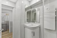 a white bathroom with a sink and a mirror at Cannes NG - Appartement à 10 mn du Palais des Festivals in Cannes