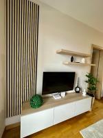 a living room with a flat screen tv on a white cabinet at Apartman SUN in Inđija
