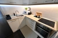a small kitchen with a sink and a stove at Apartman SUN in Inđija