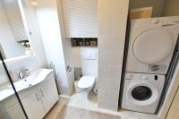 a bathroom with a washing machine and a toilet at Apartman SUN in Inđija