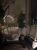 a swinging chair in a room with a plant at Apartman SUN in Inđija