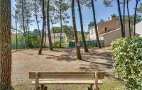 a wooden bench sitting in a yard with trees at 2 Bedroom Beautiful Home In La Faute-sur-mer in La Faute-sur-Mer