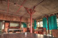 ein Esszimmer mit einem Tisch und grünen Vorhängen in der Unterkunft Bello Ethnic Bungalow & Resto in Tetebatu