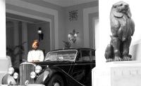 un hombre de pie junto a un coche viejo junto a una estatua en The Imperial, New Delhi, en Nueva Delhi