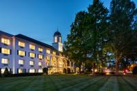 Un gran edificio con una torre de reloj por la noche. en The Madison Hotel, en Morristown